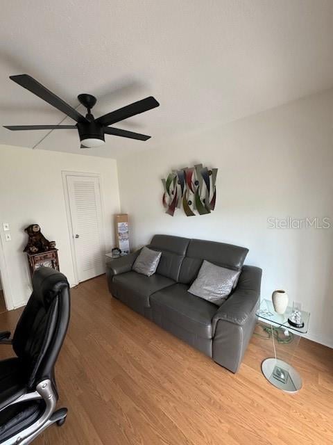 living room with ceiling fan and wood-type flooring