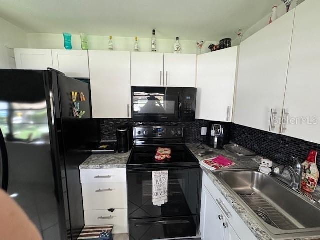 kitchen featuring tasteful backsplash, stone counters, black appliances, sink, and white cabinets