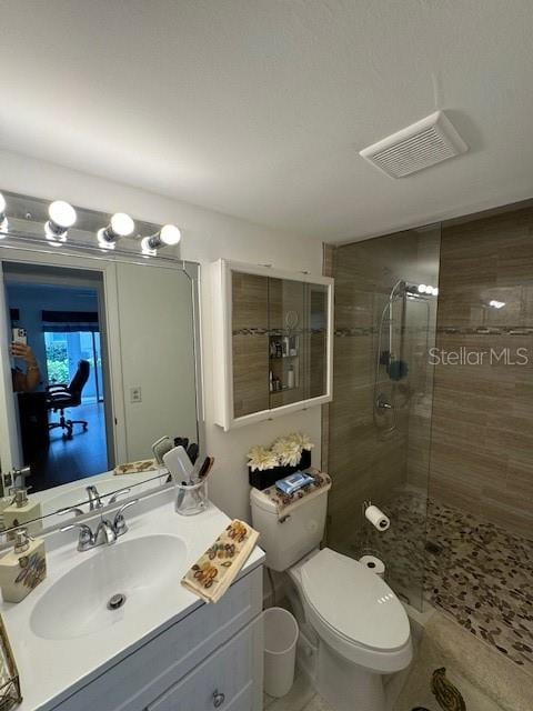 bathroom featuring walk in shower, tile flooring, toilet, and vanity