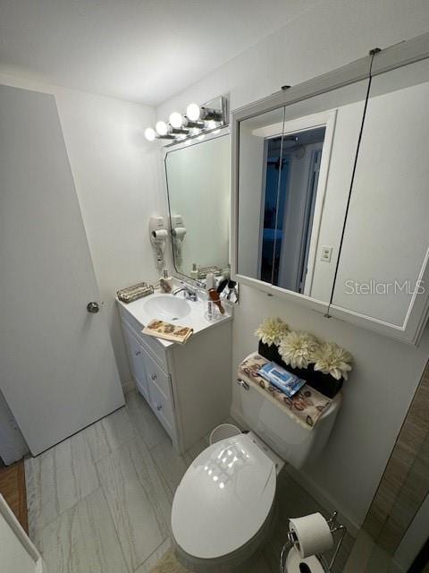 bathroom with tile floors, toilet, and vanity with extensive cabinet space