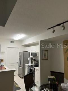 kitchen with rail lighting and stainless steel refrigerator