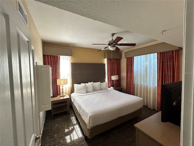 bedroom featuring ceiling fan and a textured ceiling