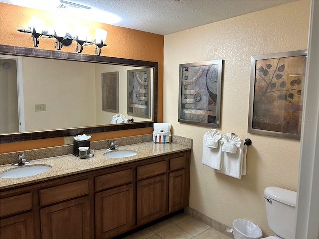 bathroom with vanity, a textured ceiling, tile patterned floors, and toilet