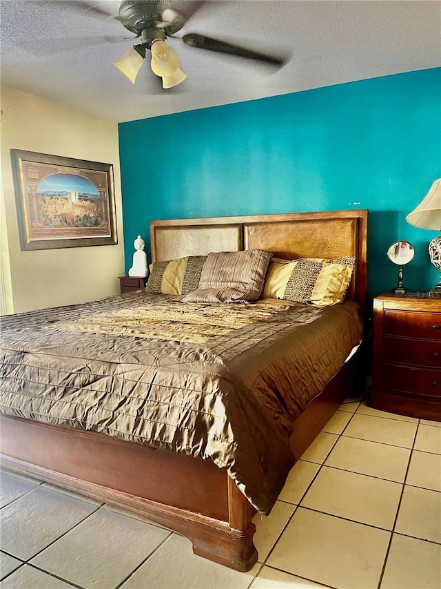 bedroom featuring light tile patterned floors, a textured ceiling, and ceiling fan