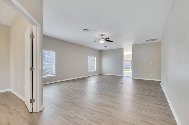 empty room with ceiling fan and light hardwood / wood-style floors