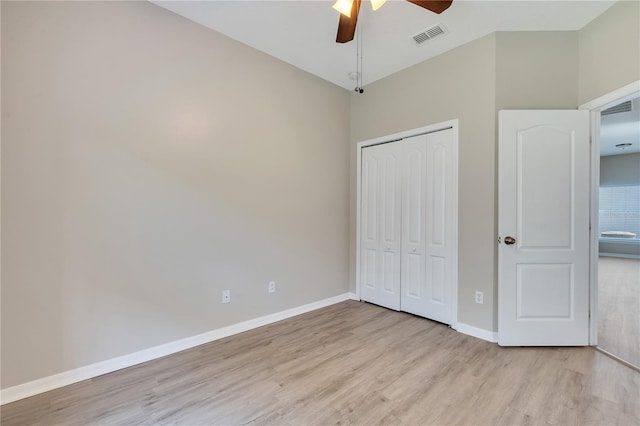 unfurnished bedroom with ceiling fan, a closet, and light wood-type flooring