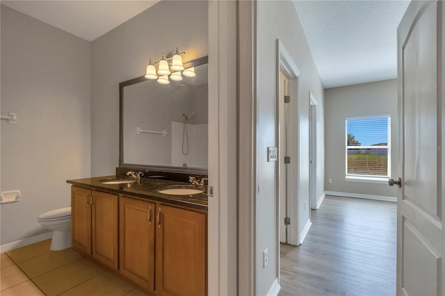 bathroom featuring walk in shower, wood-type flooring, a textured ceiling, toilet, and vanity