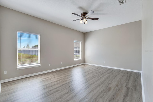 spare room featuring a textured ceiling, light hardwood / wood-style flooring, and ceiling fan