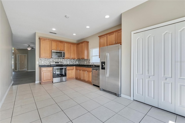 kitchen featuring tasteful backsplash, ceiling fan, light tile patterned floors, and appliances with stainless steel finishes