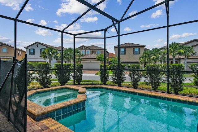 view of swimming pool featuring an in ground hot tub and a lanai