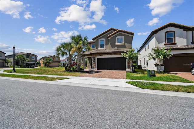 mediterranean / spanish house featuring a garage and a front lawn