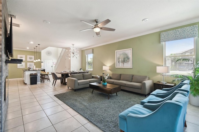 living room featuring light tile patterned flooring, ceiling fan with notable chandelier, and ornamental molding