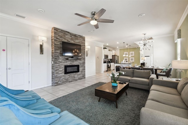 tiled living room featuring a fireplace, ceiling fan with notable chandelier, and crown molding