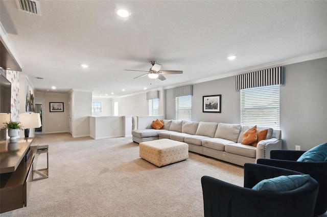 carpeted living room with ceiling fan and ornamental molding