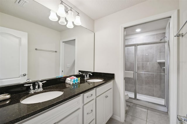 bathroom featuring toilet, vanity, tile patterned floors, and walk in shower