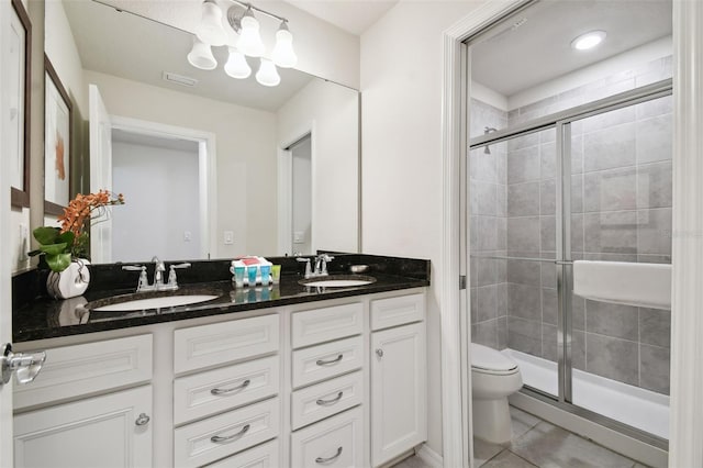 bathroom with tile patterned floors, vanity, an enclosed shower, and toilet