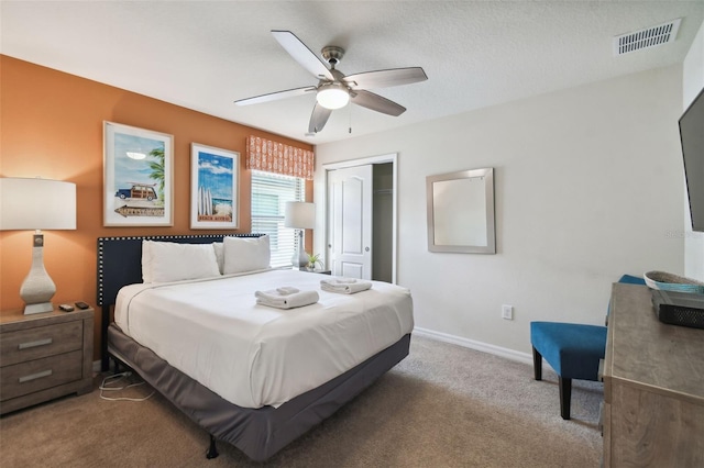 carpeted bedroom featuring a textured ceiling, a closet, and ceiling fan