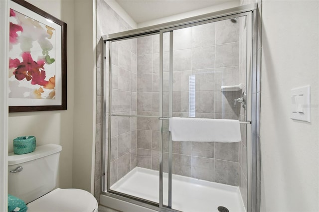 bathroom with toilet and an enclosed shower