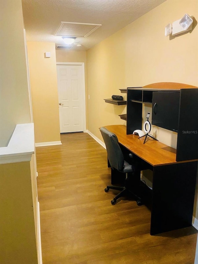 home office featuring a textured ceiling and hardwood / wood-style flooring