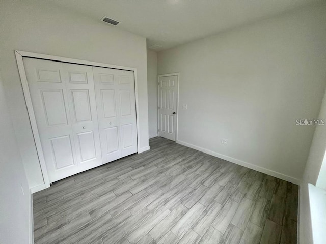 unfurnished bedroom featuring a closet and light hardwood / wood-style flooring