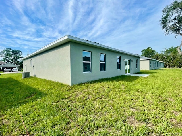 back of property featuring a yard and central AC unit