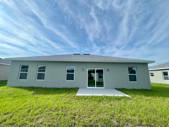 back of property featuring a lawn and a patio