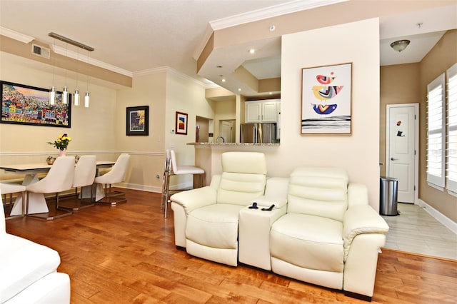 living room with ornamental molding and light wood-type flooring