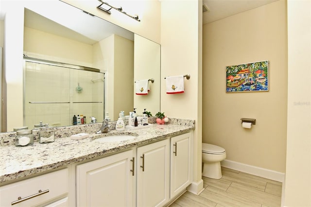 bathroom with vanity, an enclosed shower, and toilet