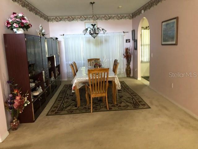 dining room featuring a wealth of natural light, carpet, and a chandelier