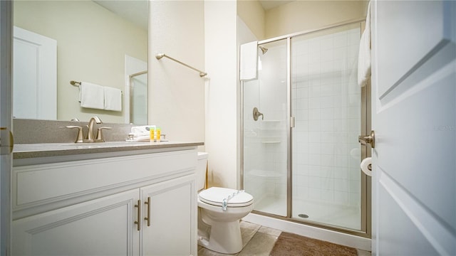 bathroom featuring tile patterned flooring, vanity, toilet, and a shower with shower door