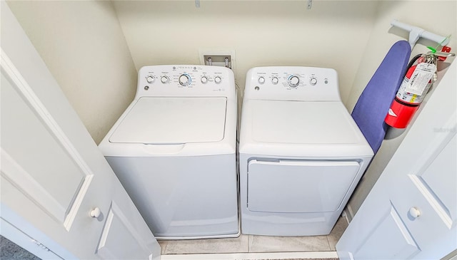 laundry room featuring light tile patterned floors and washer and clothes dryer