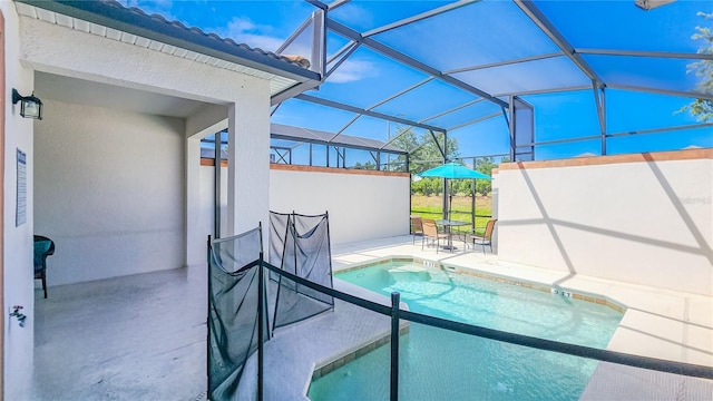 view of pool with glass enclosure and a patio area