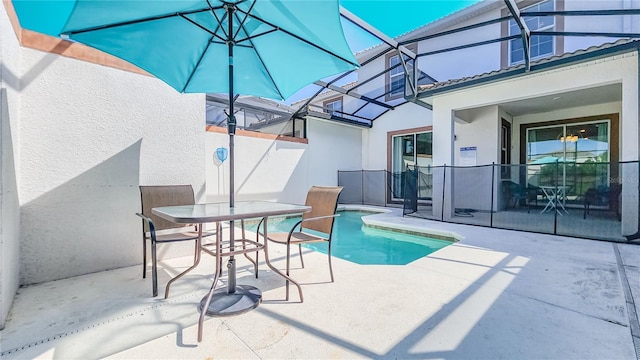 view of swimming pool featuring glass enclosure and a patio