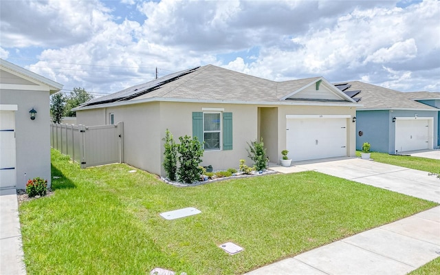 single story home featuring a garage, a front lawn, and solar panels