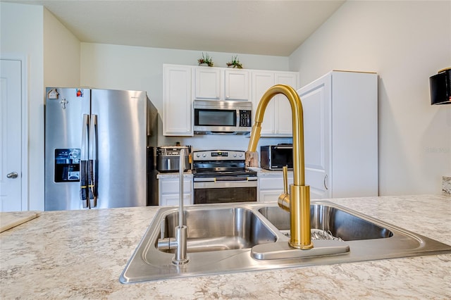 kitchen featuring stainless steel appliances and white cabinets