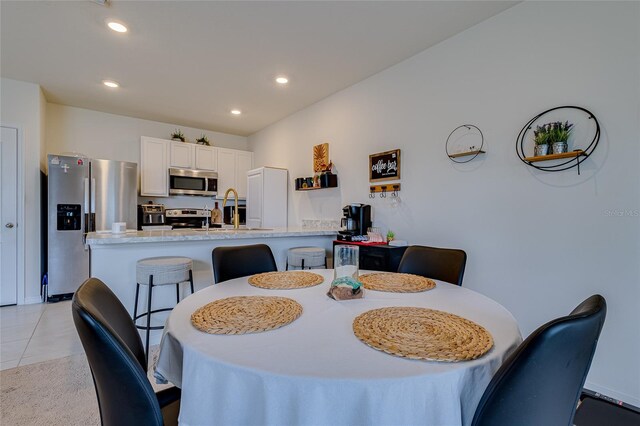 dining space with sink and light tile patterned flooring