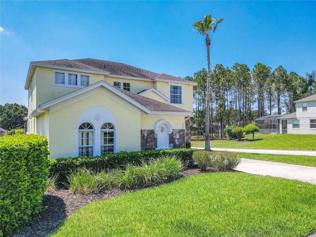 mediterranean / spanish-style house featuring a front lawn and a lanai