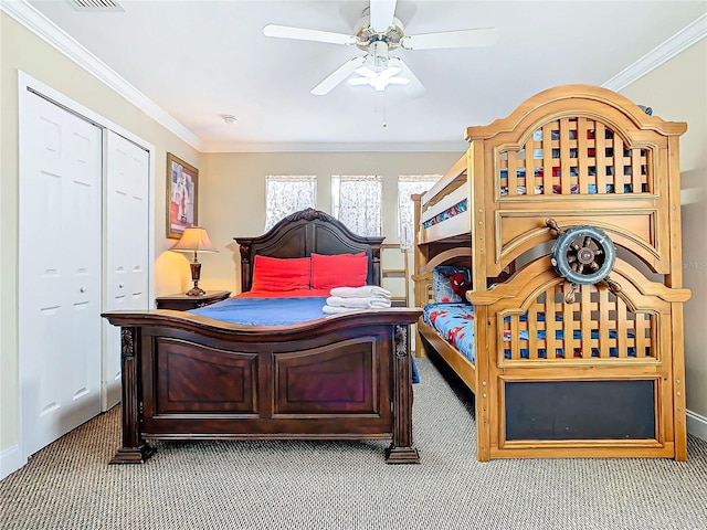 carpeted bedroom with ceiling fan, a closet, and crown molding