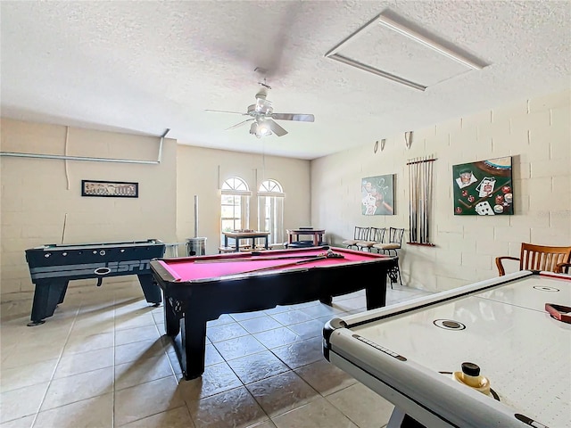 recreation room featuring ceiling fan, tile patterned floors, and a textured ceiling