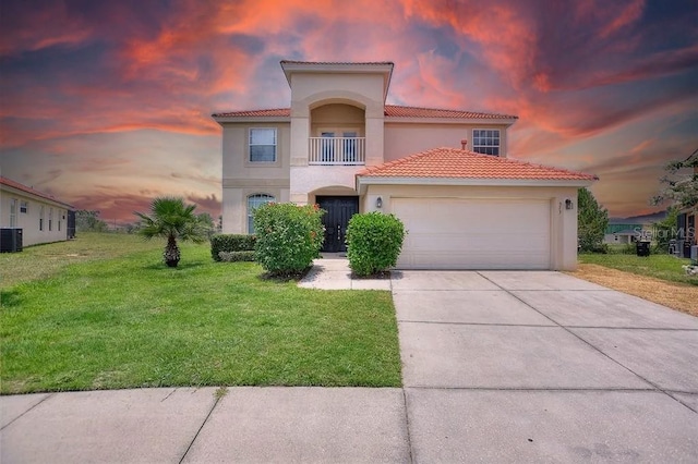 mediterranean / spanish-style home with a balcony, central AC, a garage, and a lawn