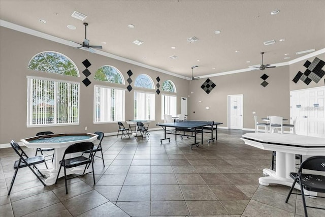 playroom with a towering ceiling, ceiling fan, and ornamental molding