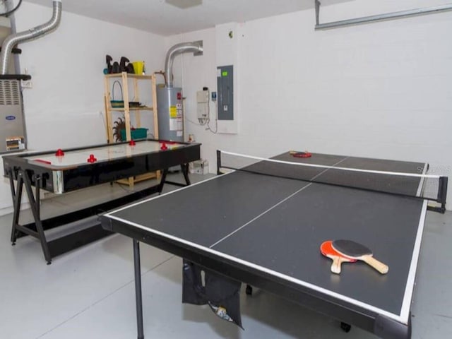 recreation room with concrete flooring, electric panel, and water heater