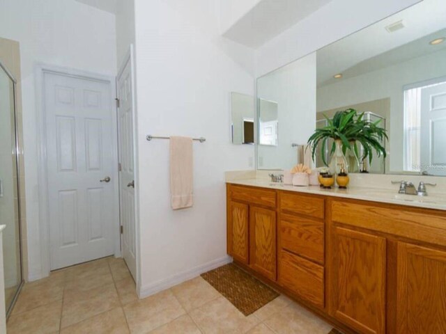 bathroom with tile patterned floors, vanity, and an enclosed shower