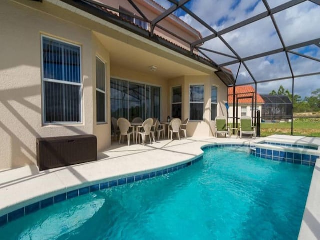 view of pool with a lanai, a patio area, and an in ground hot tub