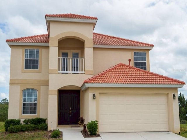 573 Viola Dr, Davenport, FL 33837 - mediterranean / spanish home with a balcony, a tile roof, stucco siding, and driveway