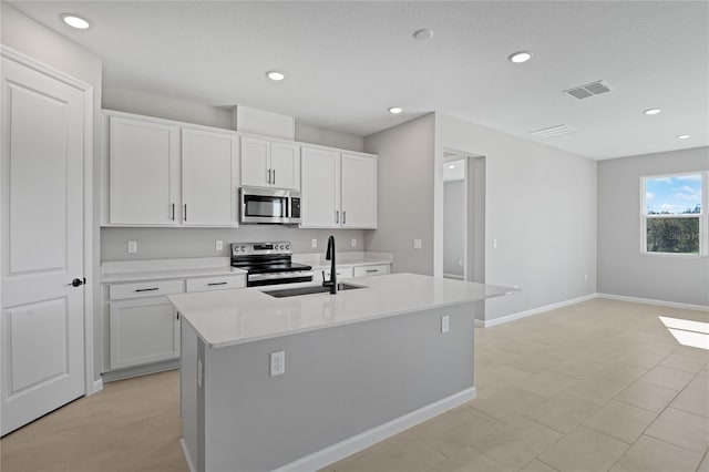 kitchen with sink, a center island with sink, white cabinets, and appliances with stainless steel finishes