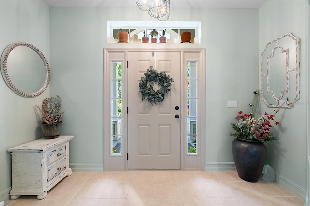 entrance foyer featuring light tile patterned floors and a notable chandelier