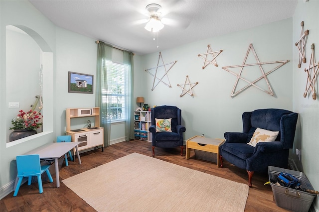 sitting room featuring dark hardwood / wood-style floors and ceiling fan