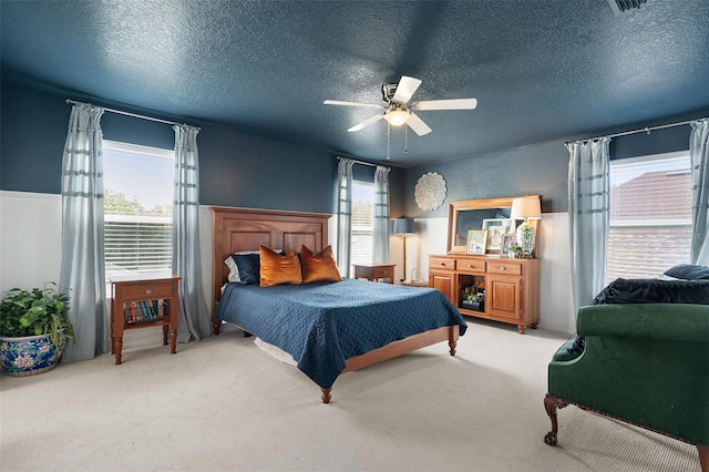 carpeted bedroom featuring a textured ceiling and ceiling fan