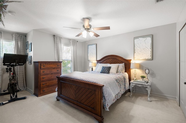 bedroom with light carpet, a textured ceiling, and ceiling fan